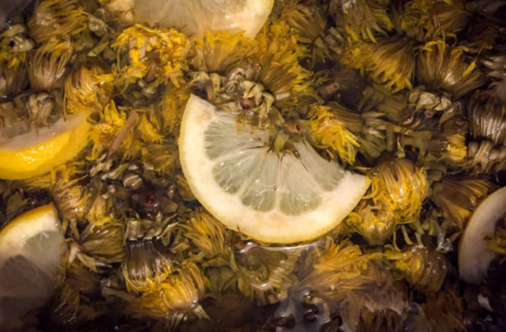 regratovi cvetovi v vodi z limono