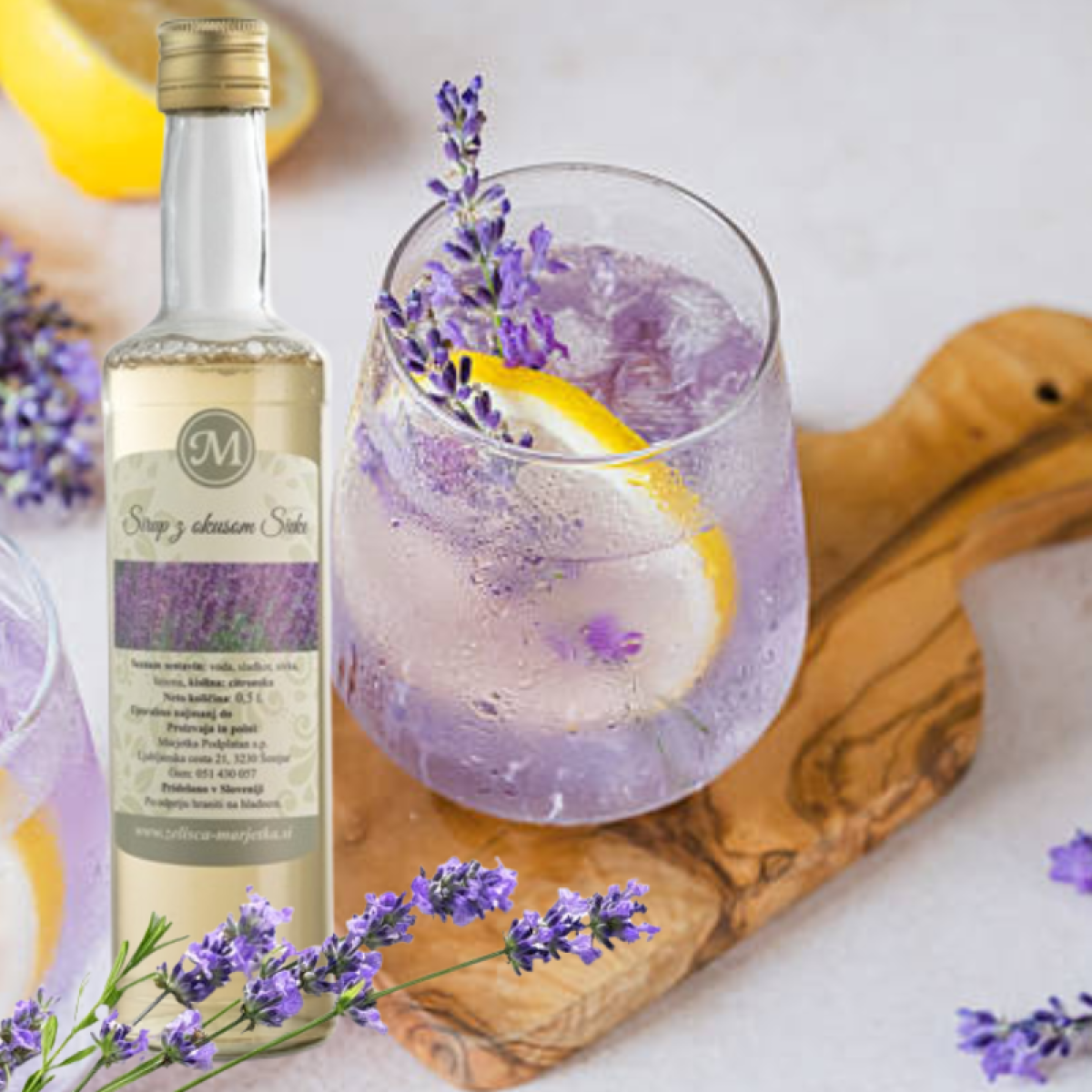 Sivkin sirup Zelišča Marjetka 0,5 L s svežo sivko, limono in kozarci osvežilnega napitka